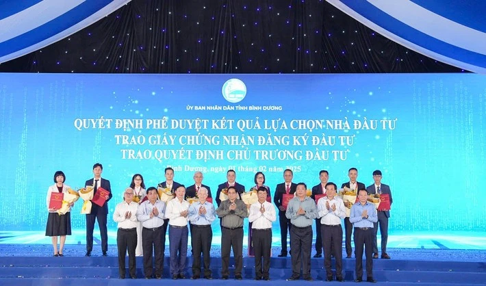 Prime Minister Pham Minh Chinh (centre, first row), and leaders of Binh Duong province handover investment certificates to enterprises. (Photo: daibieunhandan.vn)