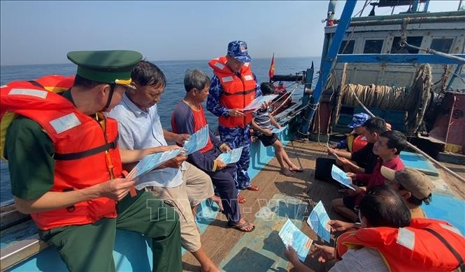 Soldiers from Coast Guard Region 3 and Border Guard provide legal information to fishermen. (Photo: VNA)