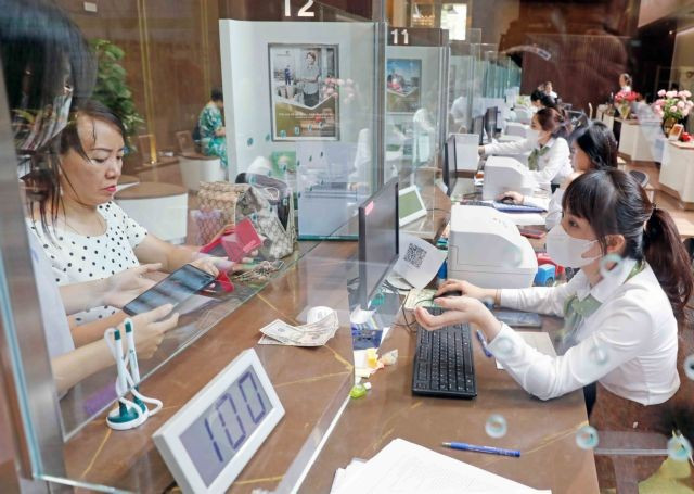 Customers completing a transaction at a Vietcombank branch. (Photo: VNA)
