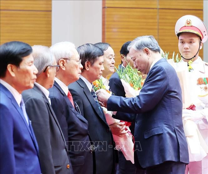 Party General Secretary To Lam presents the badges marking 80, 75, 60, 55, 50, 45, and 40-year Party membership to the veteran revolutionaries at the meeting. (Photo: VNA)