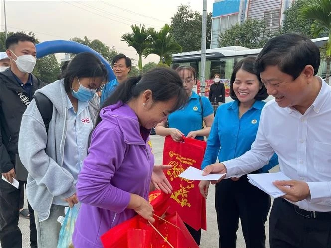 Vo Van Minh, Chairman of the Binh Duong provincial People's Committee hands over gifts to workers returning home for Tet. (Photo: VNA)