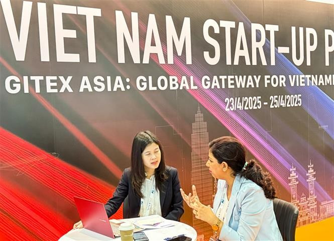 A representative from a Vietnamese startup discusses with an investor at the GITEX Asia 2025 in Singapore. (Photo: VNA)