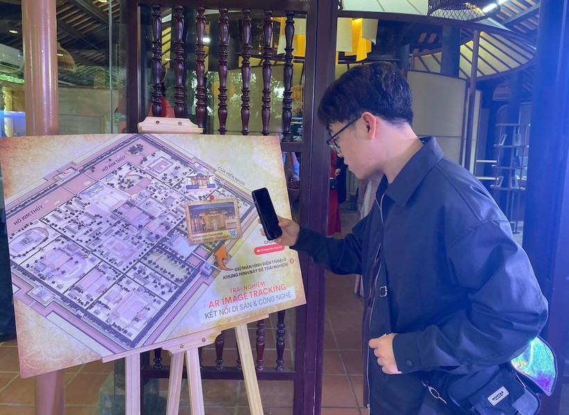 A tourist tries a feature at the culture - heritage - technology experience space within Phu Noi Vu (Internal Affairs Office) of the Hue Imperial Citadel. (Photo: laodong.vn)