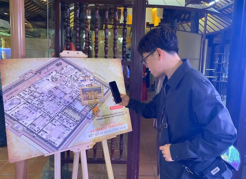A tourist tries a feature at the culture - heritage - technology experience space within Phu Noi Vu (Internal Affairs Office) of the Hue Imperial Citadel. (Photo: laodong.vn)