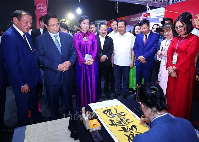 PM Pham Minh Chinh (front, second from left) and madam Ngo Phuong Ly (front, third from left), spouse of Party General Secretary To Lam, visits a Vietnamese booth at the event. (Photo: VNA)