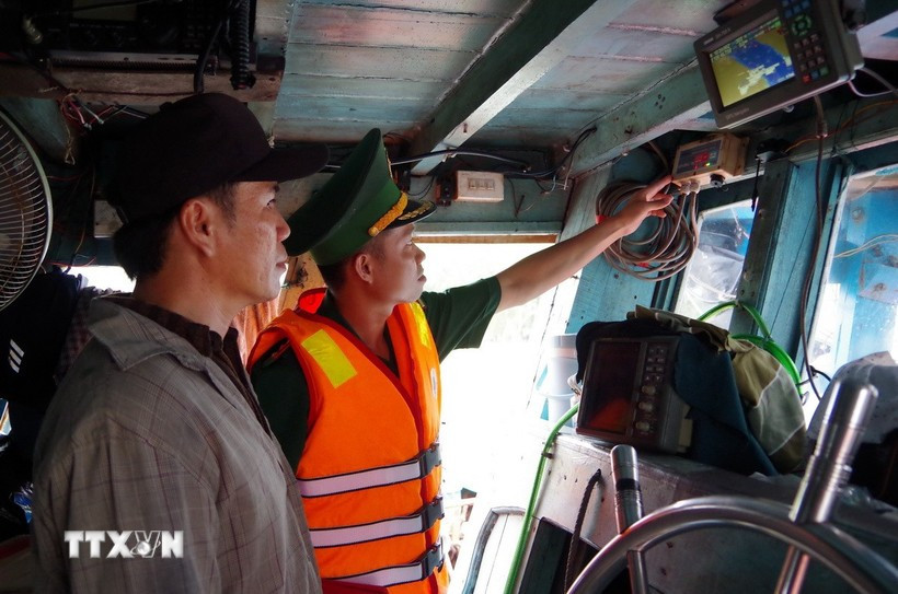 A border guard officer of Dong Thap examines the operation of the vessel monitoring system on a fishing boat. (Photo: VNA)