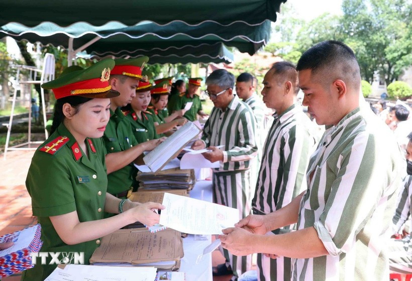 Police officers of the Phu Son 4 Prison present amnesty decisions to persons granted amnesty in 2025. (Photo: VNA)