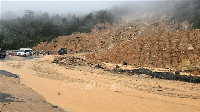 Soil and rocks from the uphill slope spill onto the road surface on Khanh Le pass. (Photo: VNA)