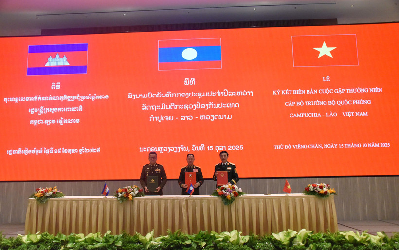 The defence ministers of Vietnam, Laos and Cambodia sign the minutes of their annual meeting in Vientiane on October 15. (Photo: VNA)