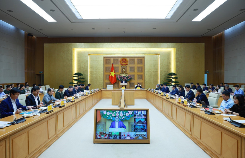Prime Minister Pham Minh Chinh (centre) chairs a hybrid meeting meeting with ministries, central agencies and local authorities on December 17 to review the implementation of the “Quang Trung Campaign” to rebuild and repair homes that are severely damaged by recent storms and floods. (Photo: VNA)