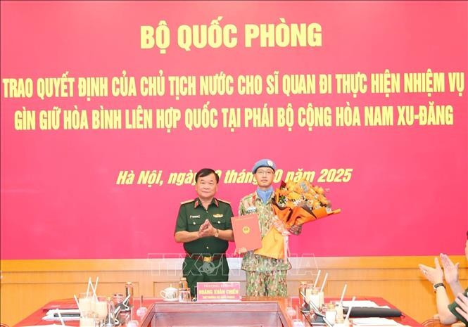 Deputy Minister of National Defence Senior Lieutenant General Hoang Xuan Chien, head of the ministry's steering committee for the participation in UN peacekeeping operations presents the decision to Major Le Vinh Hoang. (Photo: VNA)