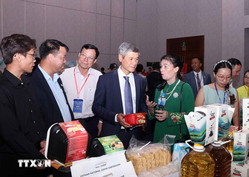 Vietnamese Ambassador to Cambodia Nguyen Minh Vu and Cambodian businesspeople visit the Vietnamese booth. (Photo: VNA)