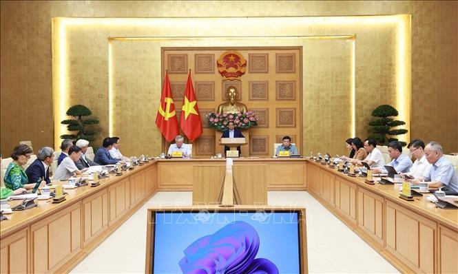 Prime Minister Pham Minh Chinh (centre) holds a working session with the Private Economic Development Research Board (Board IV). (Photo: VNA)