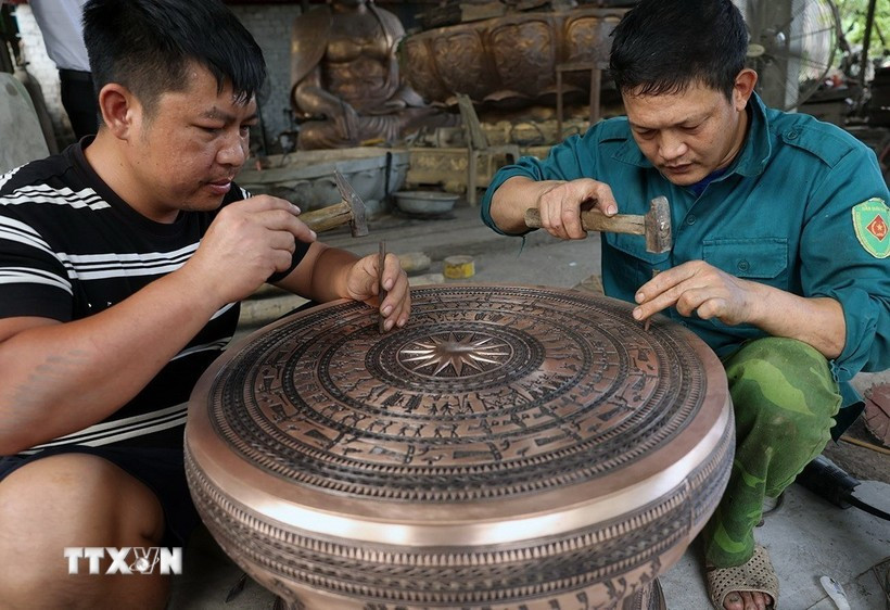 Completing a bronze drum at the workshop of artisan Dang Quoc Toan in Tra Dong bronze-casting village. (Photo: VNA)