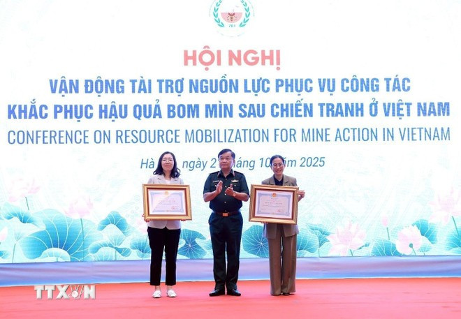 Sen. Lieut. Gen Hoang Xuan Chien, Deputy Minister of National Defence, presents Friendship Orders from the Vietnamese State President to the Korea International Cooperation Agency (KOICA) in Vietnam and the PeaceTrees Vietnam (PTVN). (Photo: VNA)
