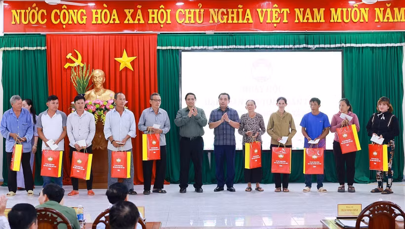 Prime Minister Pham Minh Chinh presents gifts to policy beneficiary families in De Gi commune. (Photo: VNA)