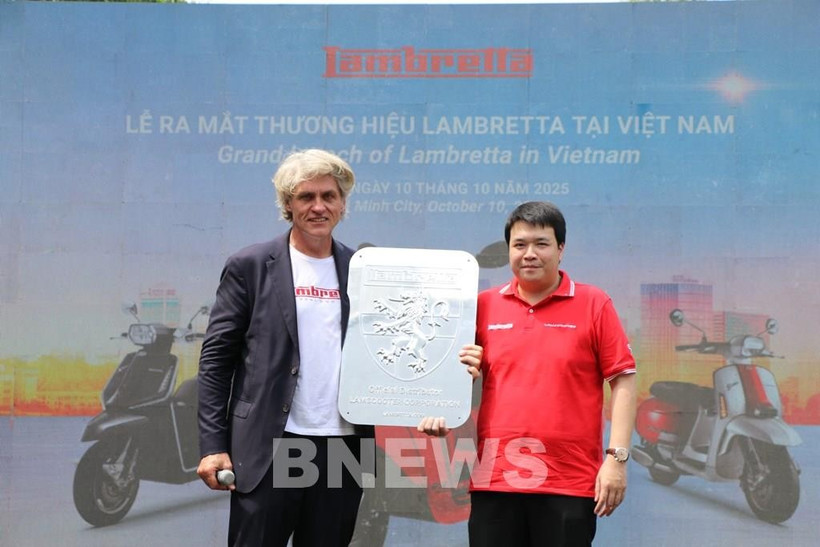 A representative of Lambretta (left) hands over the brand logo to Tran Long, Chairman of Lamscooter JSC, its exclusive distributor in Vietnam. (Photo: VNA)