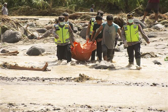 Rescue workers transport victims killed by floods and landslides in West Sumatra, Indonesia. (Photo: Xinhua/VNA)