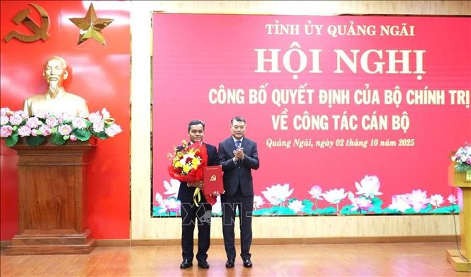 Le Minh Hung (R), Politburo member, Secretary of the Party Central Committee and Chairman of its Organisation Commission, hands over the appointment decision and congratulation flowers to Ho Van Nien, the new Secretary of the Quang Ngai Party Committee (Photo: VNA)