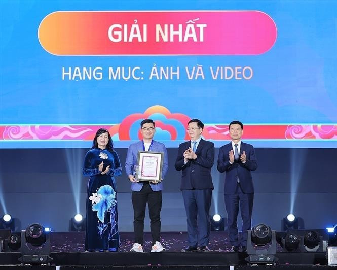Deputy Prime Minister Mai Van Chinh (second, right), Minister of Science and Technology Nguyen Manh Hung (first, right), and Chairwoman of the Vietnam Association of Photographic Artists Tran Thi Thu Dong (first, left) present insignia and certificate to the first-prize winner. (Photo: VNA) 