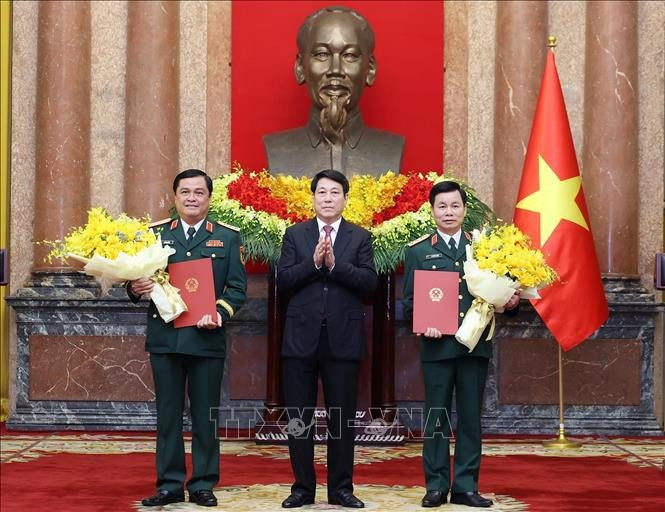 State President Luong Cuong (middle) presents congratulatory flowers to the two promoted officers (Photo: VNA)