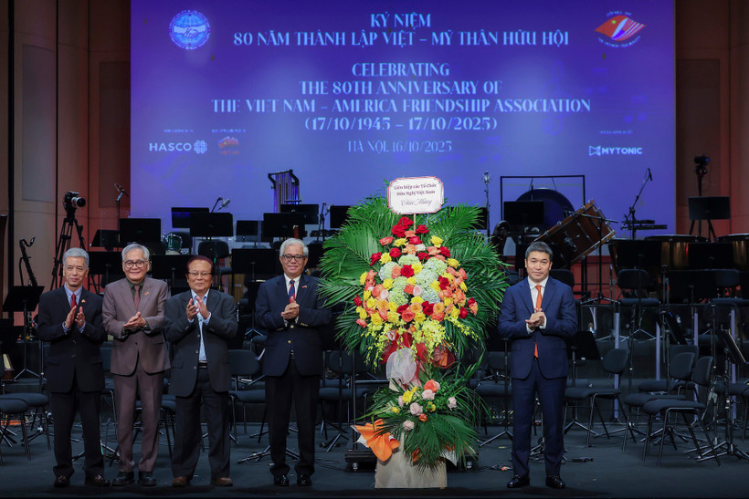 Phan Anh Son (R), President of the Vietnam Union of Friendship Organisations (VUFO) presents greeting flowers to the Vietnam - USA Society at the ceremony. (Photo: VNA)