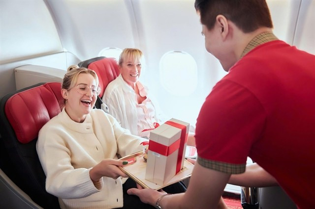 A Vietjet flight attendant offers gifts to international passengers during a flight. (Photo: courtesy of Vietjet)
