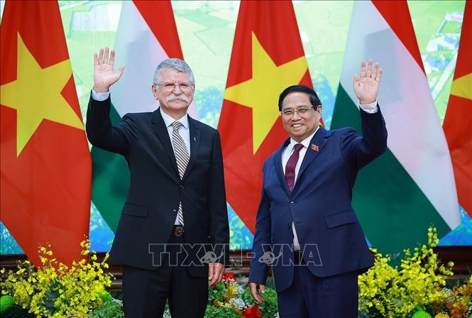 Prime Minister Pham Minh Chinh (R) welcomes Speaker of the Hungarian National Assembly Kover Laszlo in Hanoi on October 20. (Photo: VNA)