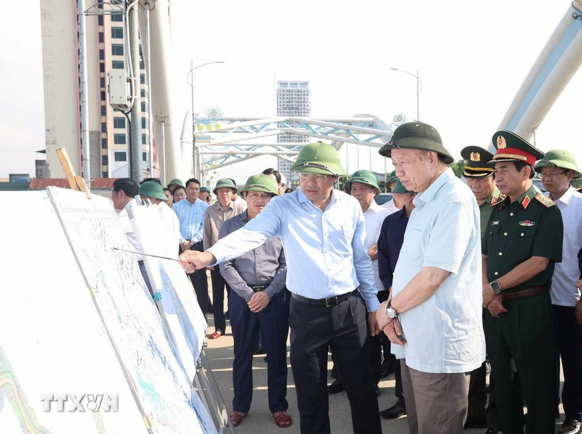 Party General Secretary To Lam listens to a leader of Thai Nguyen province report on flood and storm recovery work at Ben Tuong bridge. (Photo: VNA)
