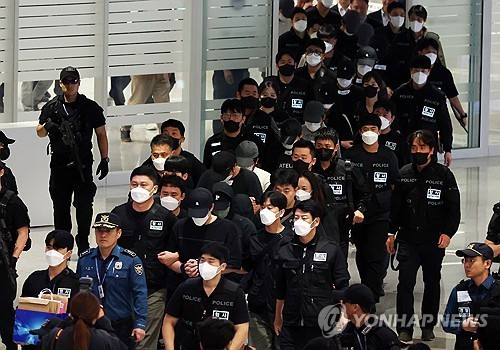 Korean nationals who had been detained in Cambodia arrive at Incheon International Airport, just west of Seoul, under police escort on October 18. (Photo: Yonhap) 