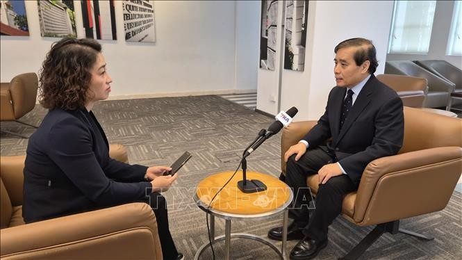 Professor Vu Minh Khuong, of the Lee Kuan Yew School of Public Policy (right), talks to a Vietnam News Agency correspondent in Singapore. (Photo: VNA)