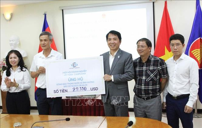 A representative of the Vietnam–Cambodia Business Association (VCBA) presents its donated fund to the leaders of the Vietnamese Ambassador to Cambodia Nguyen Minh Vu (2nd from left). (Photo: VNA)