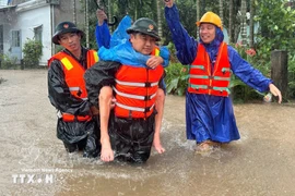 Military forces take a resident from a flooded area. Photo: VNA