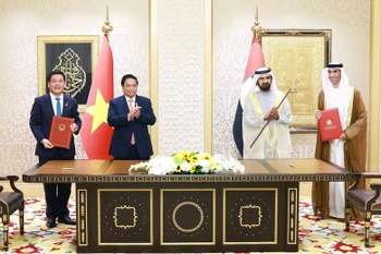 Prime Minister Pham Minh Chinh (second from left) and UAE Vice President and Prime Minister Sheikh Mohammed bin Rashid Al Maktoum (second from right) witness the signing of Comprehensive Economic Partnership Agreement between Vietnam and the United Arab Emirates. (Photo: VNA)