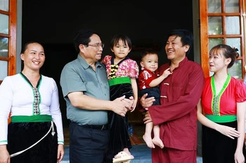 Prime Minister Pham Minh Chinh (2nd from left) visits the family of Xa Van Vong (2nd from right) in Son Phu hamlet, Cao Son commune, Da Bac district, Hoa Binh province, who recently moved into new homes as part of the temporary housing eradication initiative. (Photo: VNA)