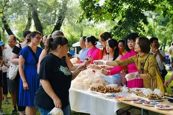 Visitors to the Vietnamese Culture Day event have some Vietnamese food. (Photo: VNA broadcasts)