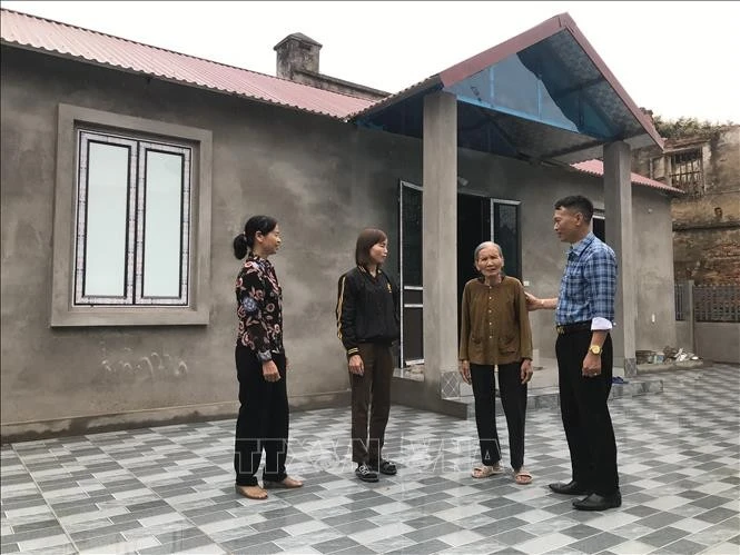Local officials visit and encourage a family after they move into their new home under Hai Duong’s temporary and dilapidated housing eradication programme. (Photo: VNA)