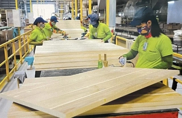 Workers at a factory in the southern province of Binh Duong process wood for export. (Photo: VNA)