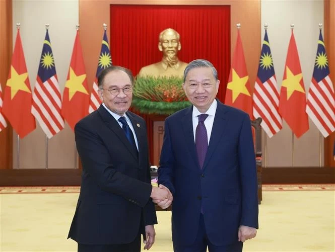 General Secretary of the Communist Party of Vietnam Central Committee To Lam (R) shakes hands with Malaysian Prime Minister Anwar Ibrahim. (Photo: VNA)