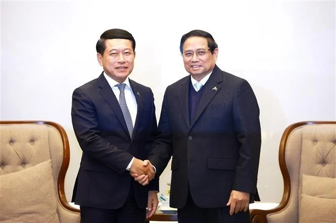 Prime Minister Pham Minh Chinh (R) shakes hands with Lao Deputy PM Saleumxay Kommasit. (Photo: VNA)