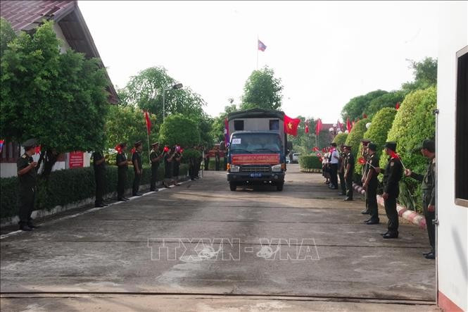 Lao military personnel and local people bid farewell as the remains of Vietnamese volunteer soldiers and experts are repatriated. (Photo: VNA) 