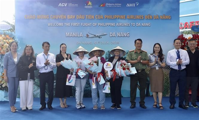 Presenting flowers and gifts to first passengers arriving in Da Nang on direct Manila–Da Nang flight. (Photo: VNA) 