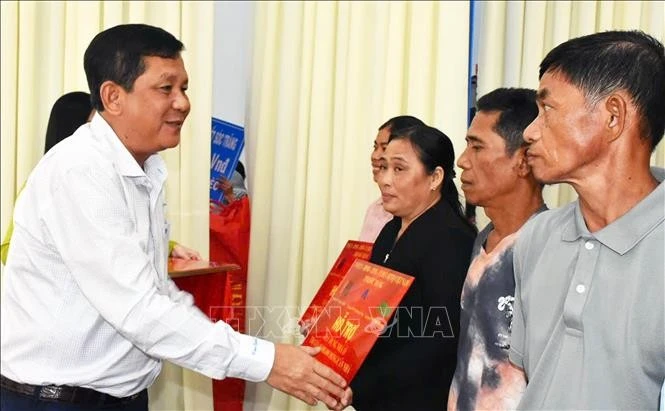 Secretary of the Vinh Chau Township Party Committee Duong Sa Kha hands over the token of new homes to underprivileged families. (Photo: VNA)