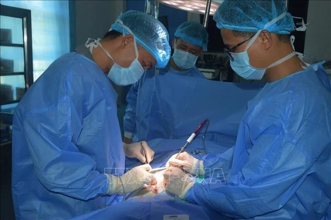 Doctors are performing a surgery on a patient (Photo: VNA)