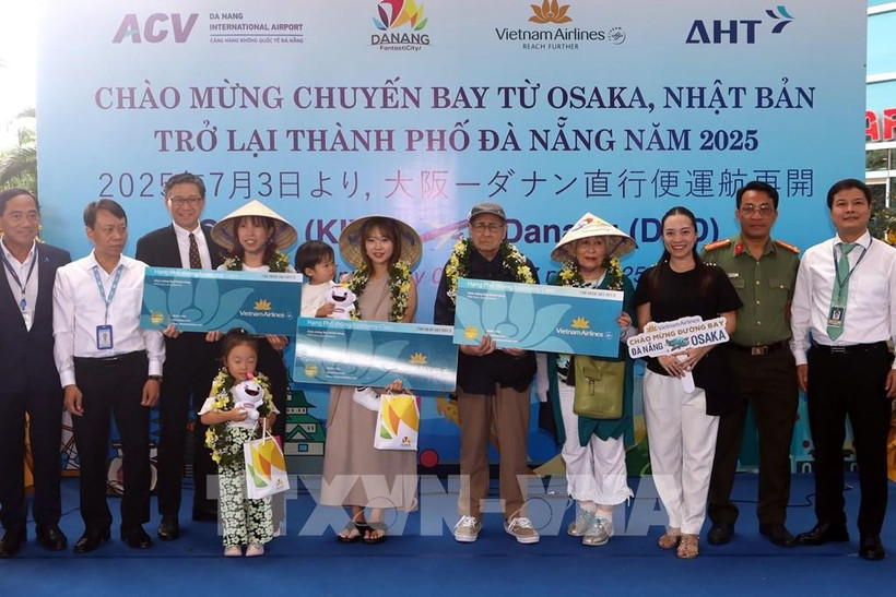 The organising committee presents flowers and gifts to lucky passengers boarding the Osaka – Da Nang flight at the welcome ceremony. (Photo: VNA) 