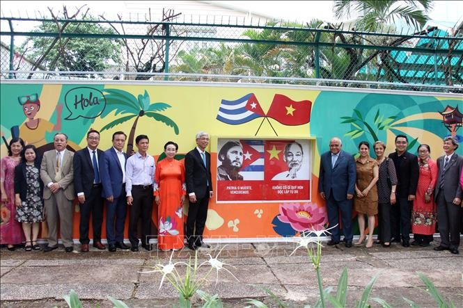 Delegates pose for a photo in front of a mural promoting Vietnam–Cuba friendship. (Photo: VNA)