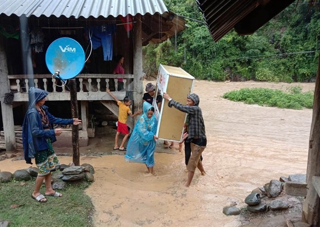 A family in Muong Xen commune in Nghe An province move their belongings to safe places amid the flooding. (Photo: VNA) 