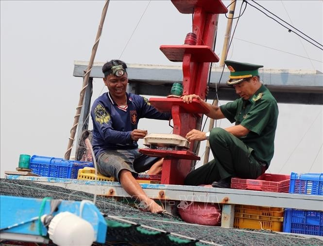 A fishing vessel owner and officers of the Dak Lak provincial Border Guard Command inspect the vessel monitoring system (VMS) on board. (Photo: VNA)
