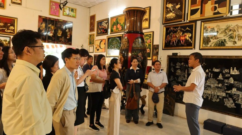 Visitors are introduced to the history of lacquer paintings at the Dinh Hoa lacquerware workshop. (Photo: VietnamPlus)