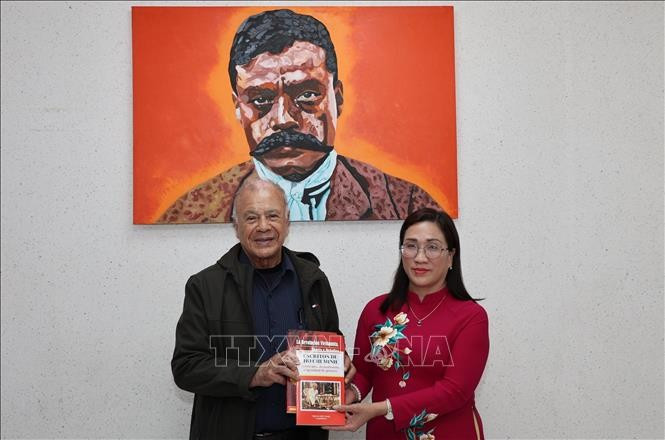 Alberto Anaya Gutiérrez, General Secretary of the Labour Party (PT) of Mexico, presents Dinh Thi Mai, Deputy Head of the Party Central Committee’s Commission for Information, Education and Mass Mobilisation, with Spanish-language publications on Vietnam printed and distributed by the PT in Latin America. (Photo: VNA) 